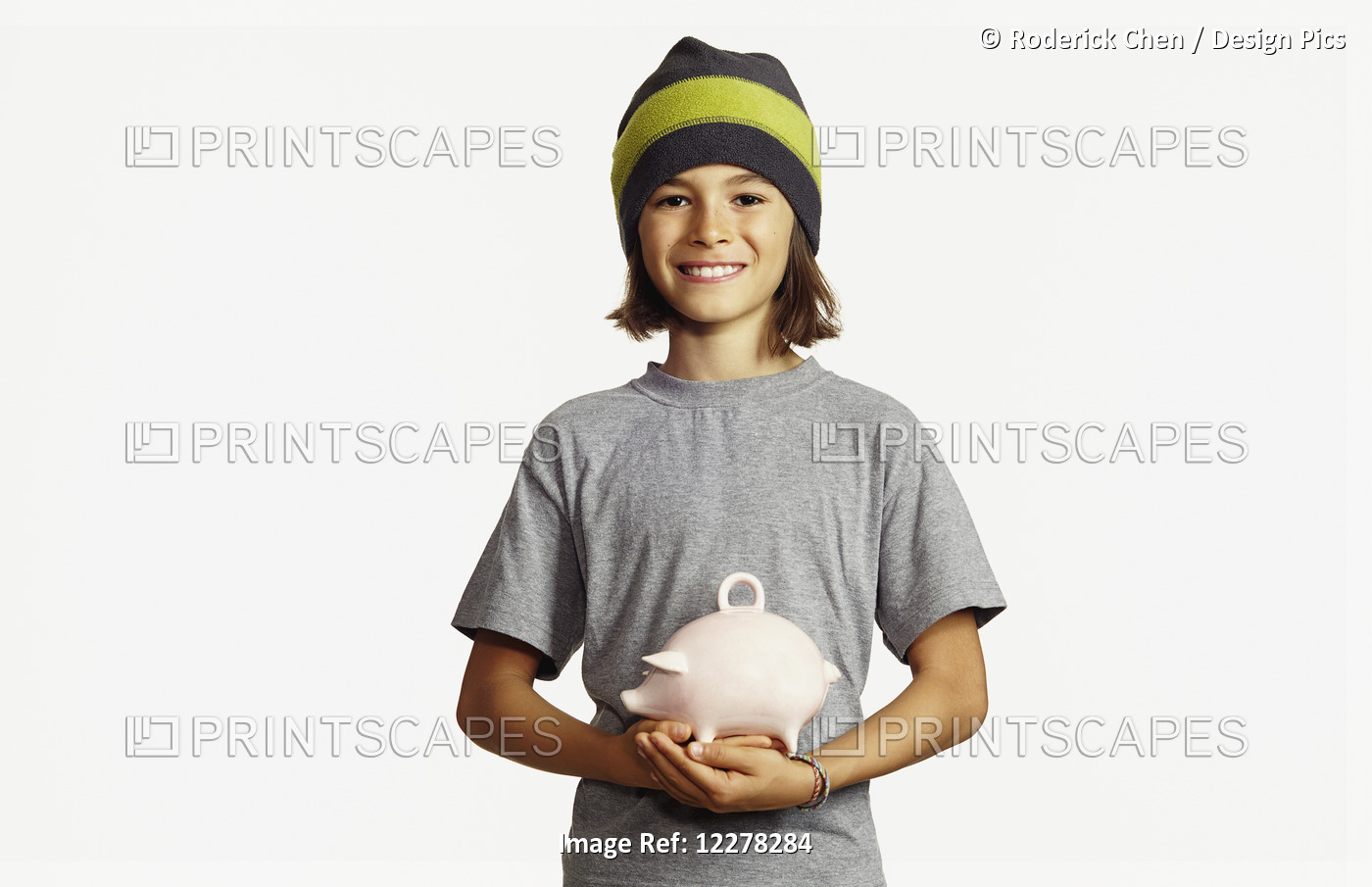 Young Boy Holding Ceramic Piggy Bank; Montreal, Quebec, Canada