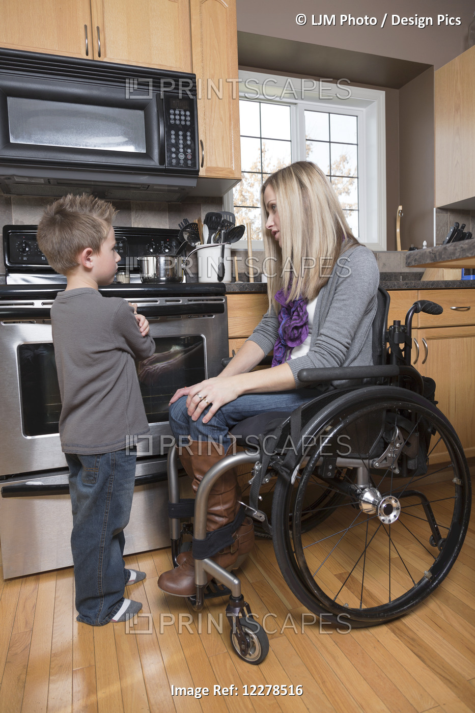 Young Disabled Mother Talking With Her Young Son In Her Kitchen; Spruce Grove, ...