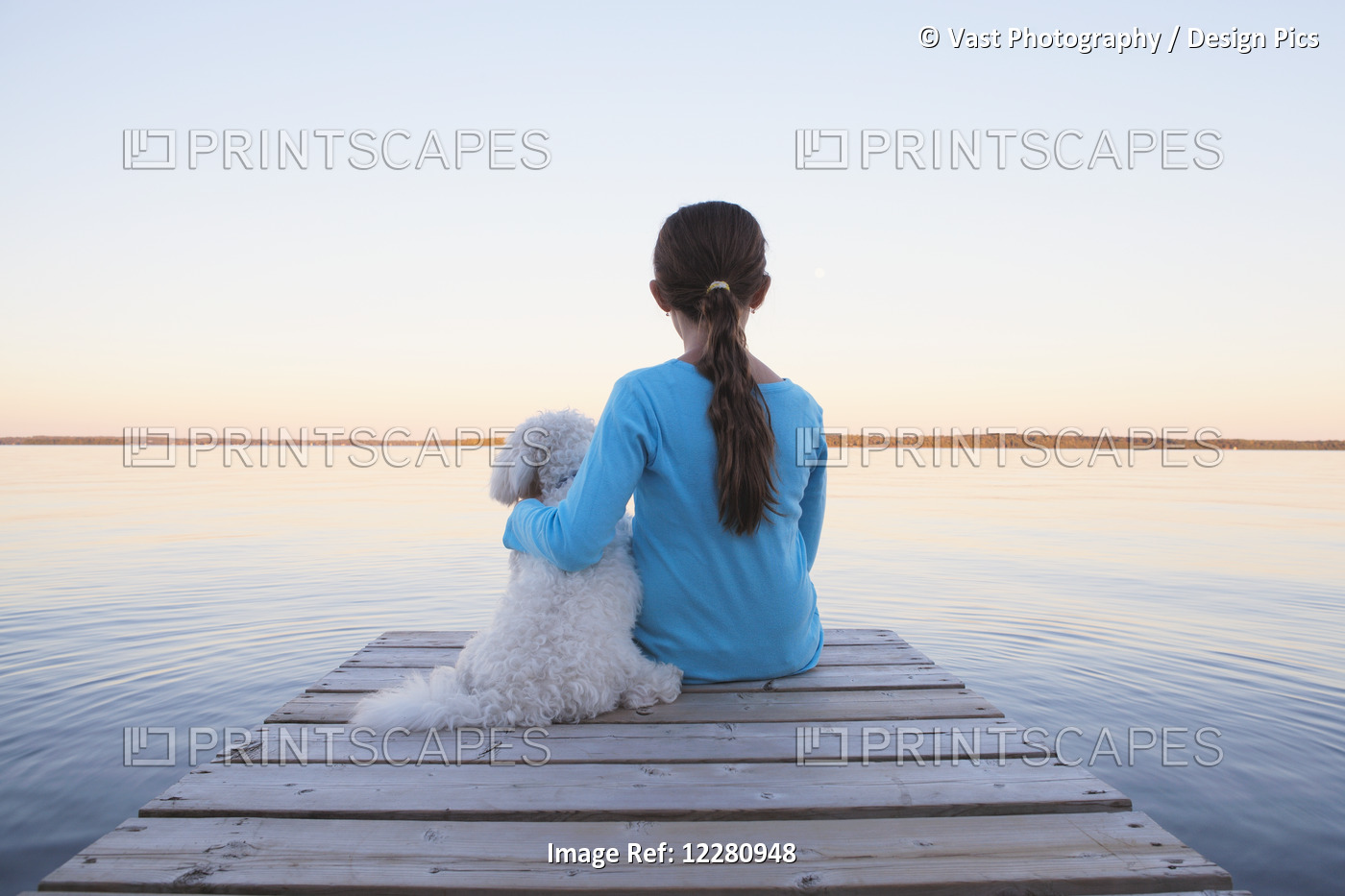 Girl Sitting With Her Dog At End Of Dock On Balsam Lake; Ontario, Canada