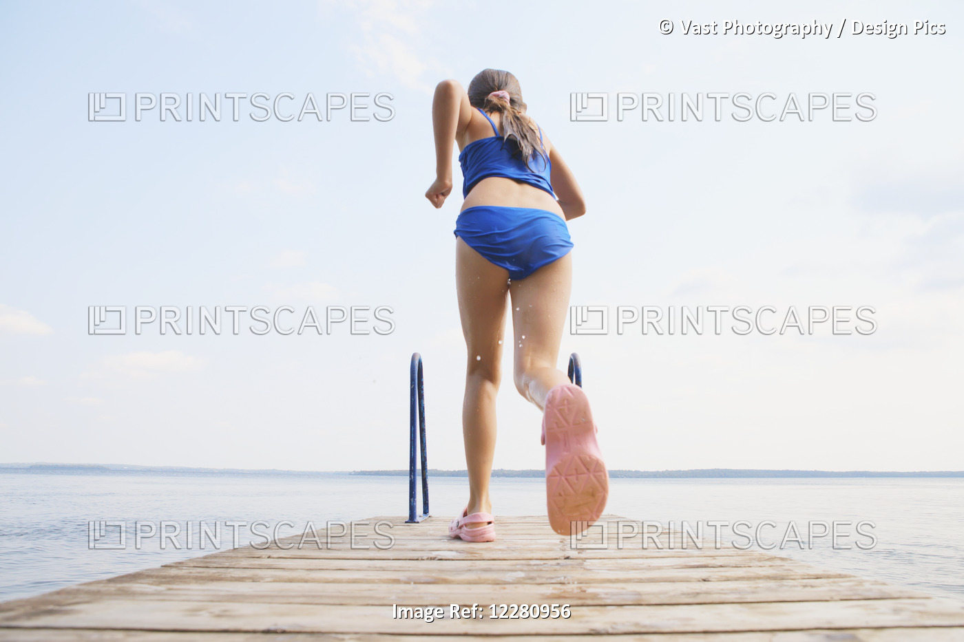 Girl Running To Jump Off End Of Dock On Balsam Lake; Ontario, Canada