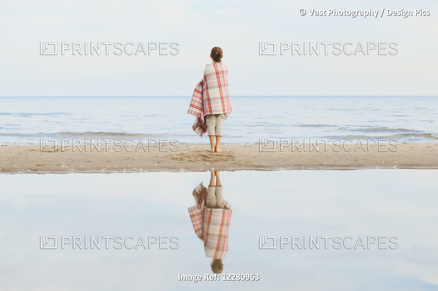 Girl Reflected In Water Standing On Beach Wrapped In Blanket; Toronto, Ontario, ...