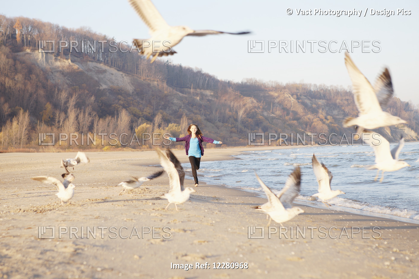 Girl At Beach Running Through Flock Of Seagulls; Toronto, Ontario, Canada