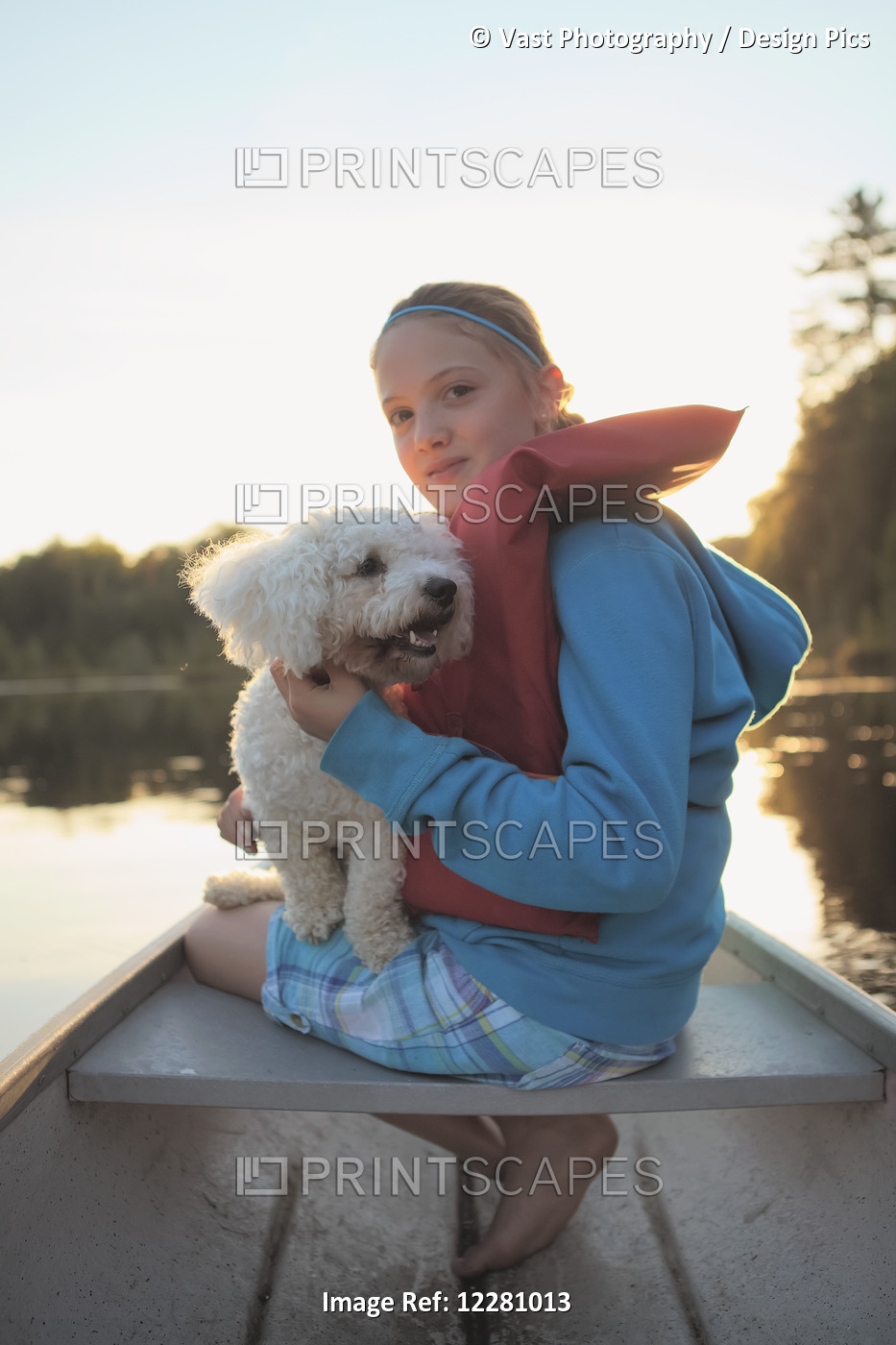 Girl Sitting In A Canoe With Her Dog On Crystal Lake; Ontario, Canada