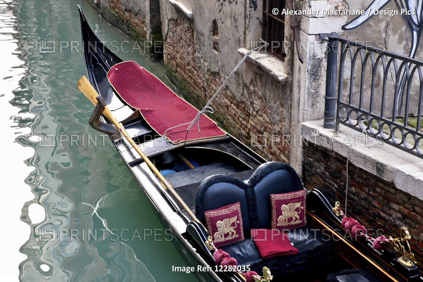 Gondola Moored Along A Building In A Canal; Venice, Italy