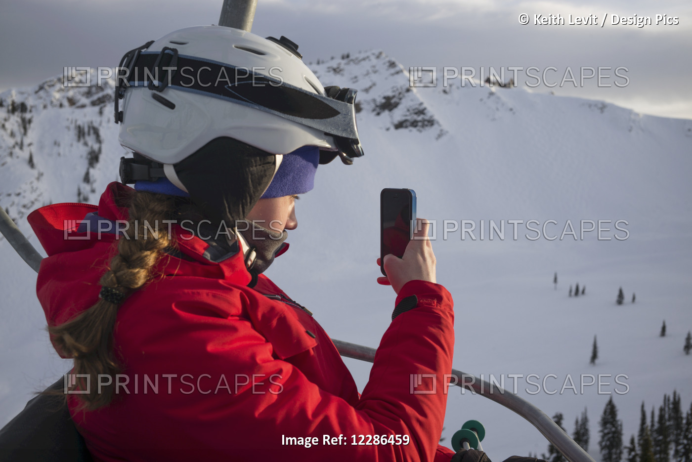A Skier On A Chair Lift At A Ski Resort Takes A Picture With A Smart Phone, ...