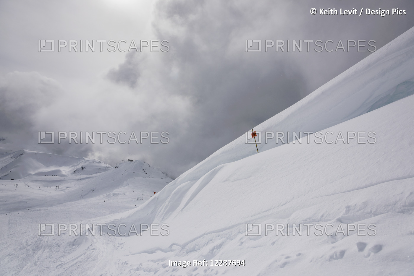 Drifting Snow On A Mountain Top And A Red Flag On A Ski Run; Whistler, British ...