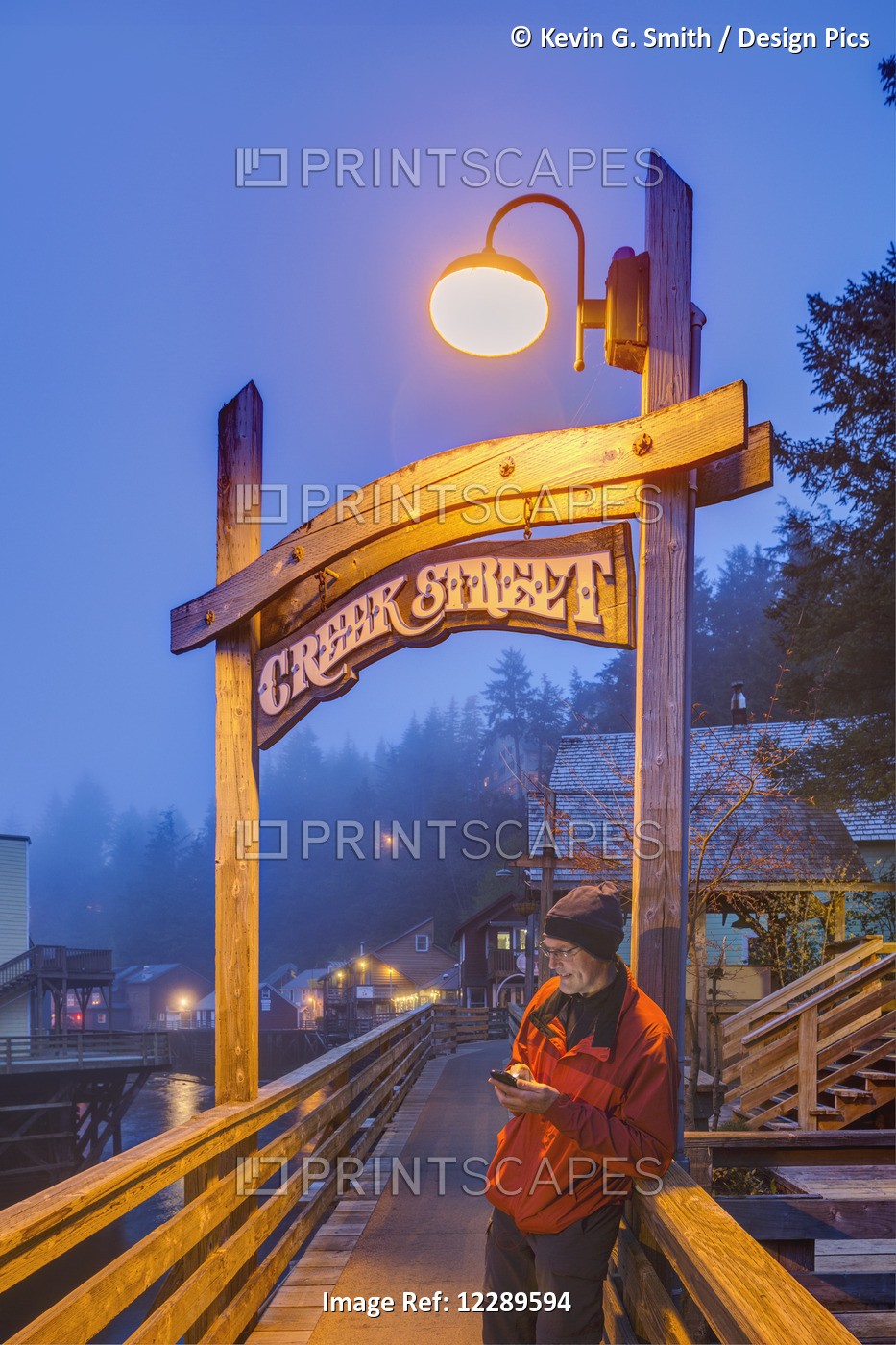Man Texting On A Cell Phone Near The Creek Street Sign And Boardwalk On A Foggy ...