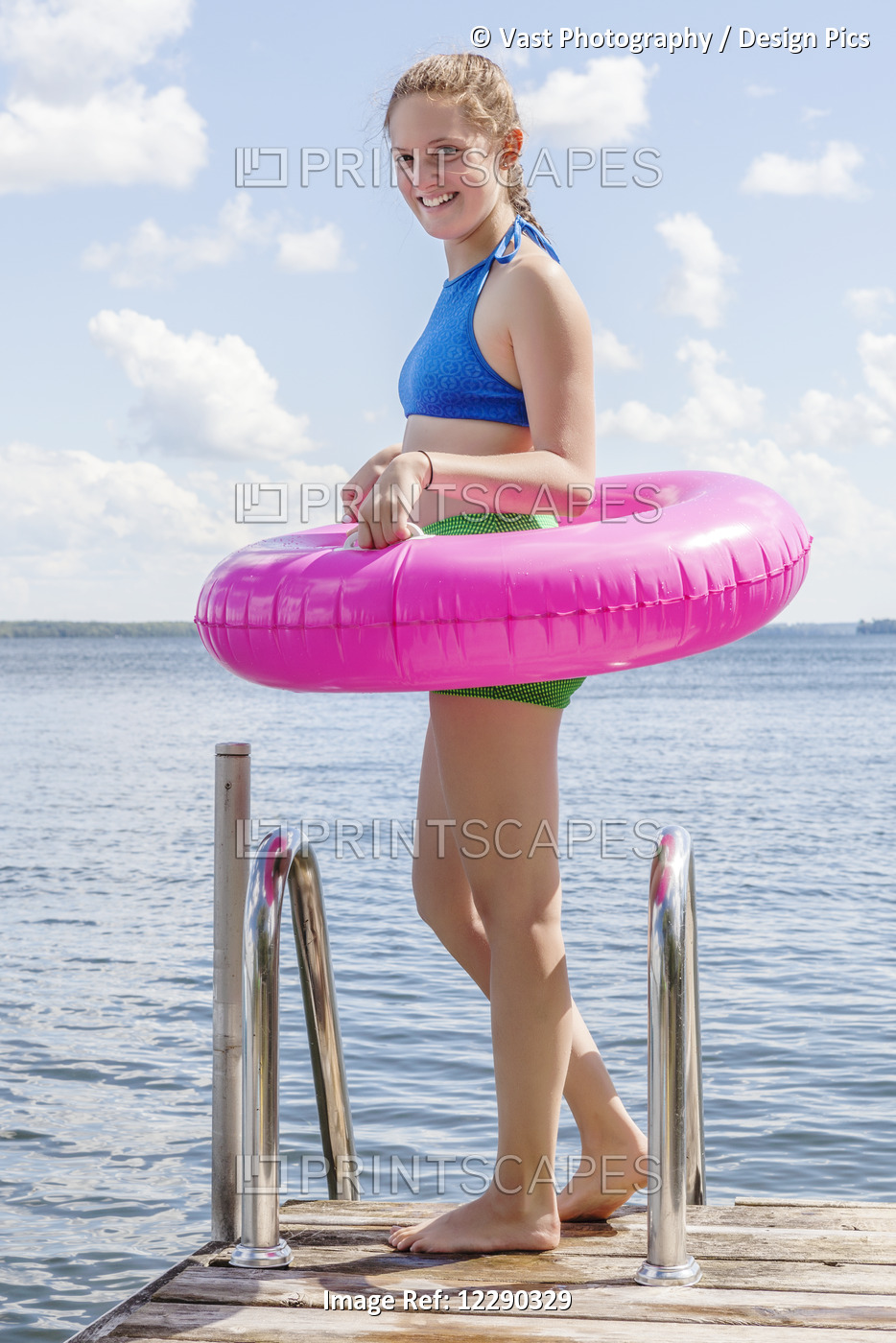 Girl Standing On Edge Of Dock By Balsam Lake Wearing Inflatable Ring; Ontario, ...
