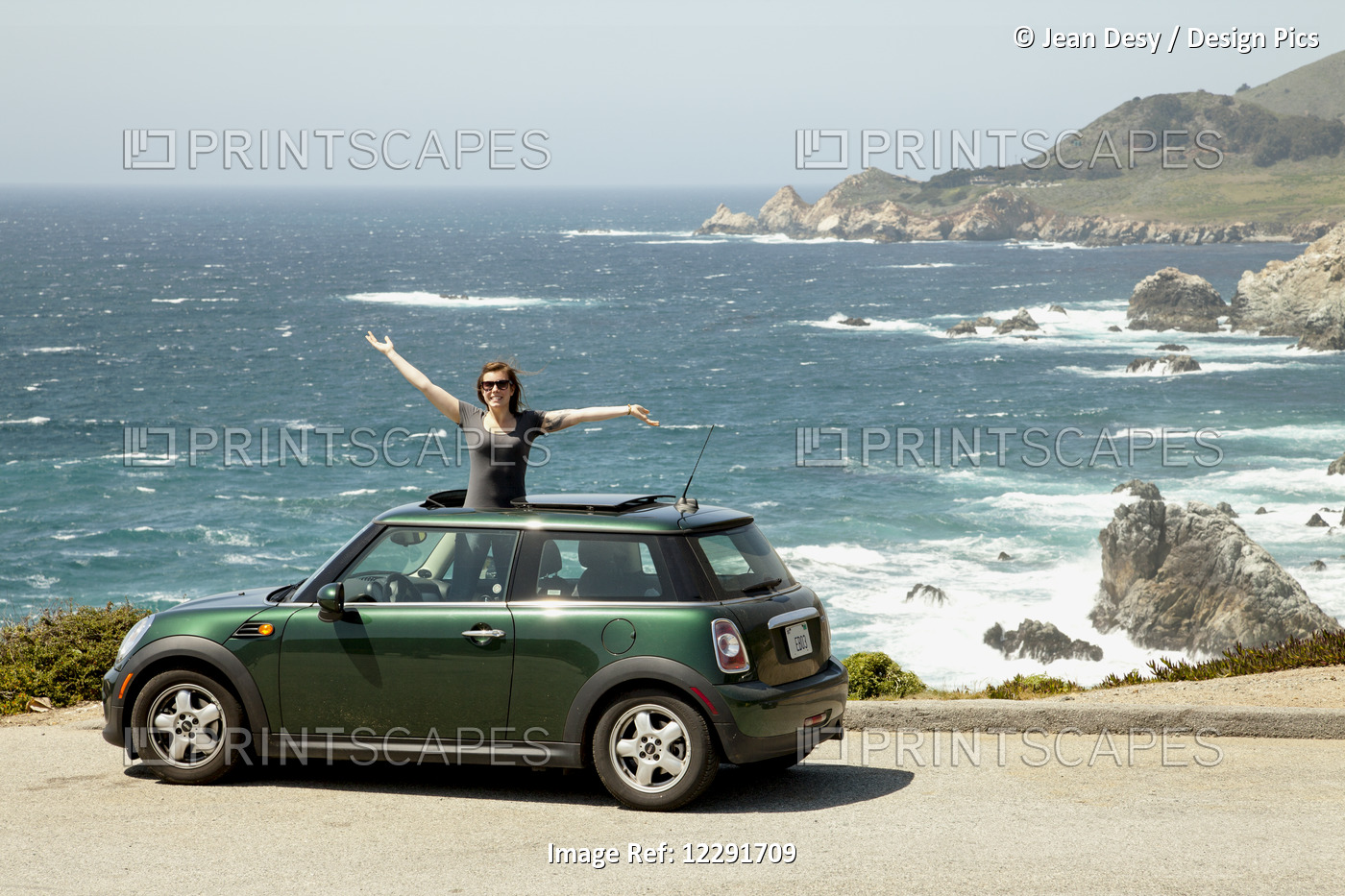 Young Woman Smiling And Standing Up Out Of The Sunroof Of Her Car On The Side ...