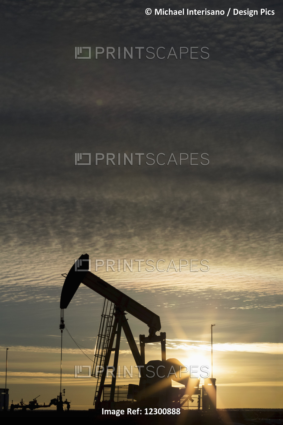 Silhouette Of Pump Jack At Sunrise With Sun Burst And Colourful Clouds In The ...