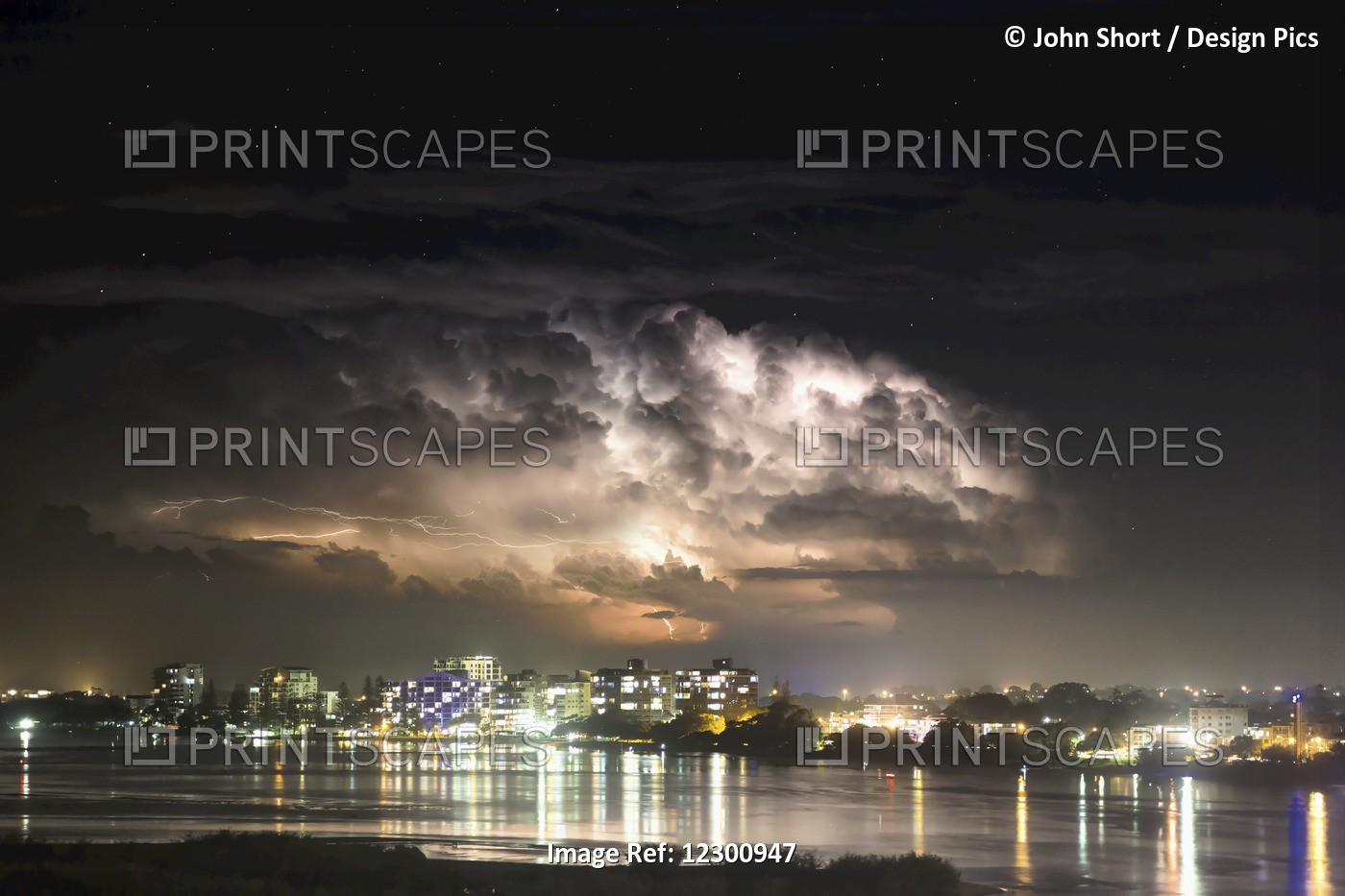 Buildings Along The Coastline Illuminated And Reflected In The Water At ...