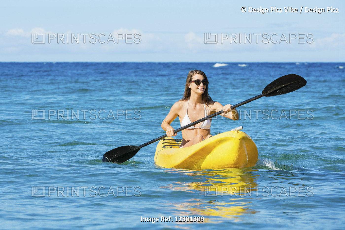 Woman Kayaking In The Ocean On Vacation In Hawaii