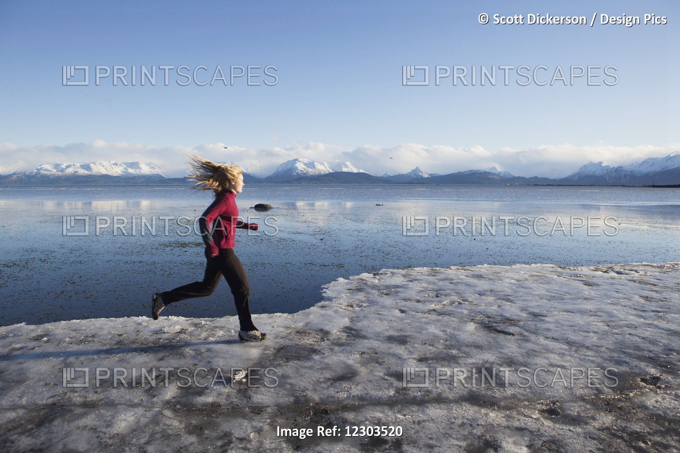 Woman Running On The Ice Covered Beach In Homer, Kenai Peninsula, Southcentral ...