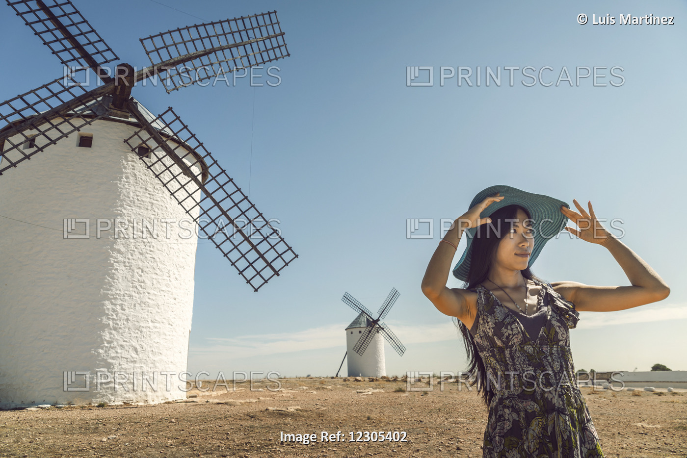A Young Chinese Woman Standing Beside The Famous Windmills In Campo Criptana, ...