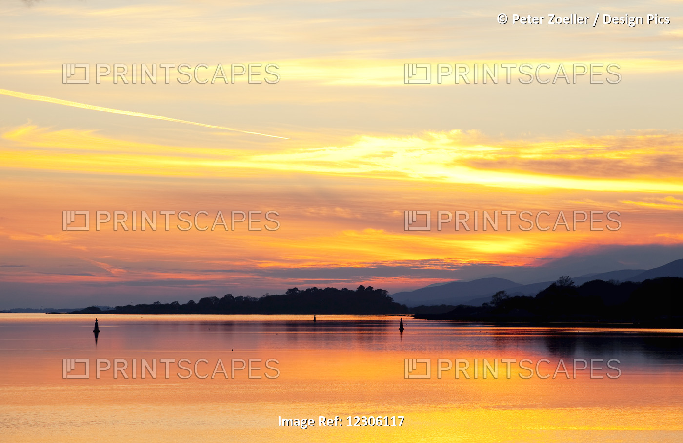 A Dramatic And Colourful Sunset Reflected In Water With Silhouetted Shoreline ...