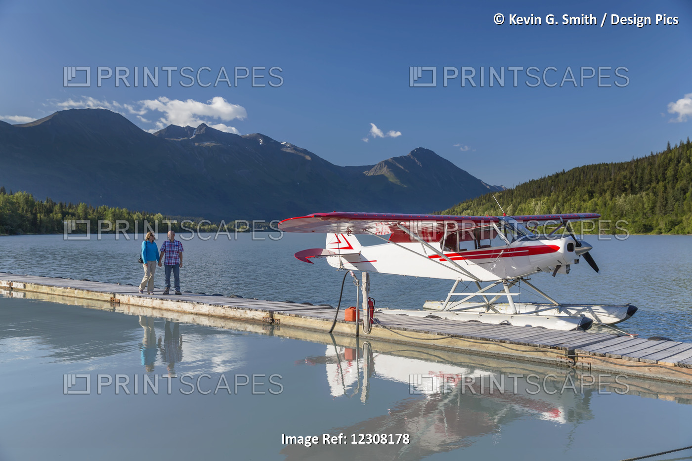 A Woman And A Man Stand On A Dock Where A Float Plane Is Docked, Trail Lake ...