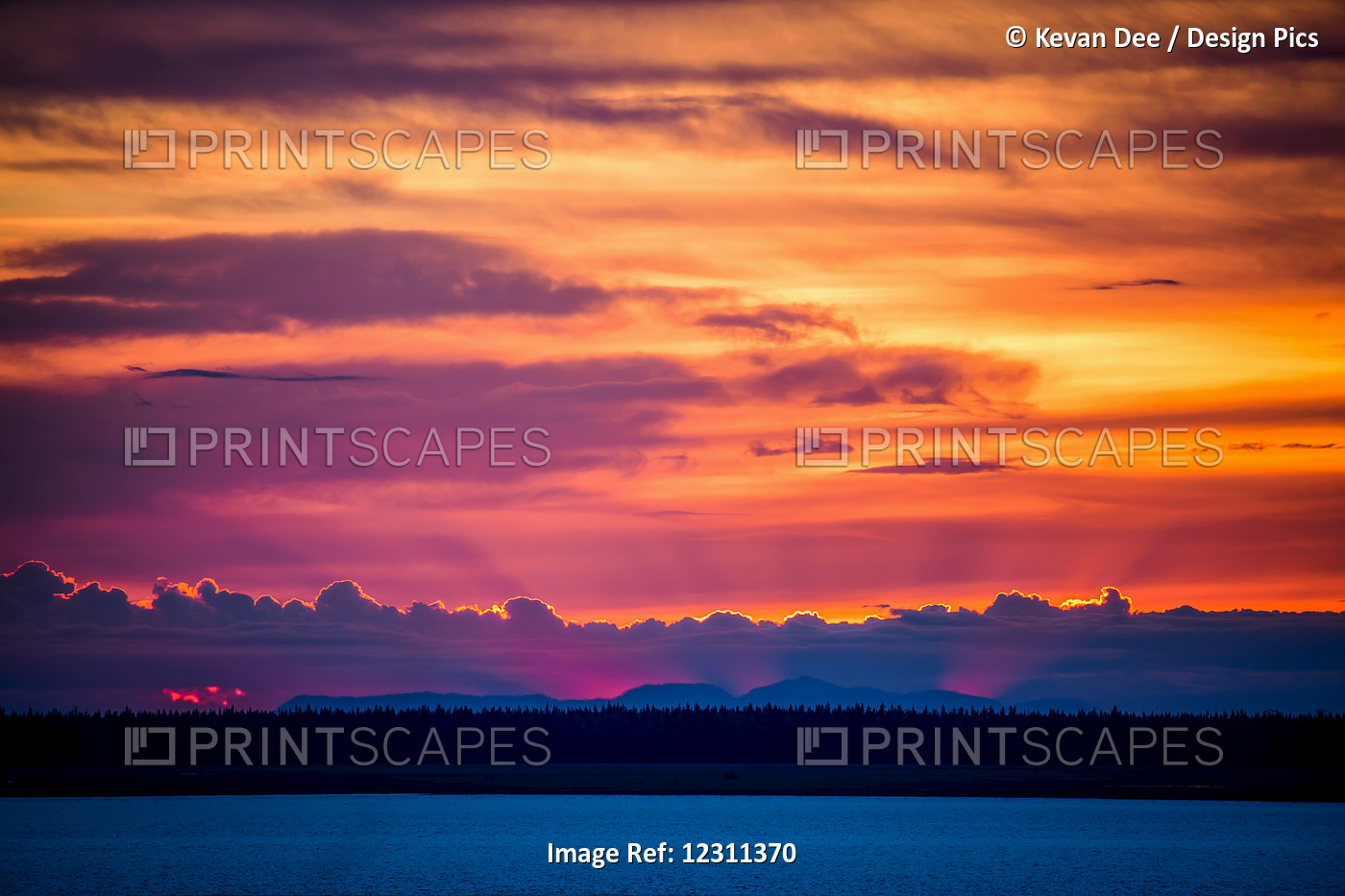 Light Shines From Behind Clouds And Mountains At Sunset; Anchorage, Alaska, ...