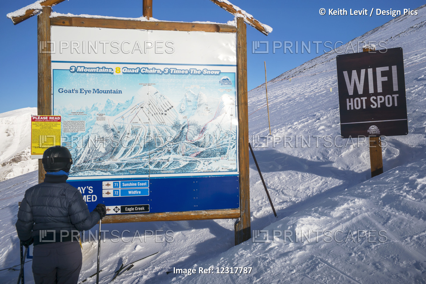 A Skier Stands Looking At A Map Of The Sunshine Village Ski Resort With A Wifi ...