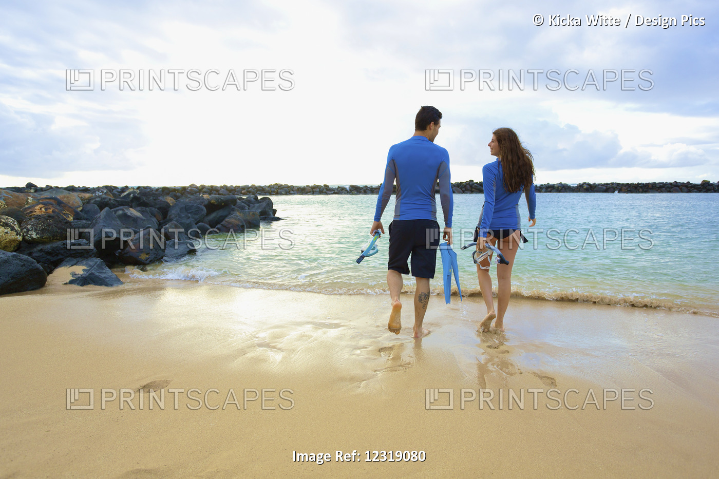 A Couple Walks Into The Water From Lydgate Beach Holding Flippers And ...