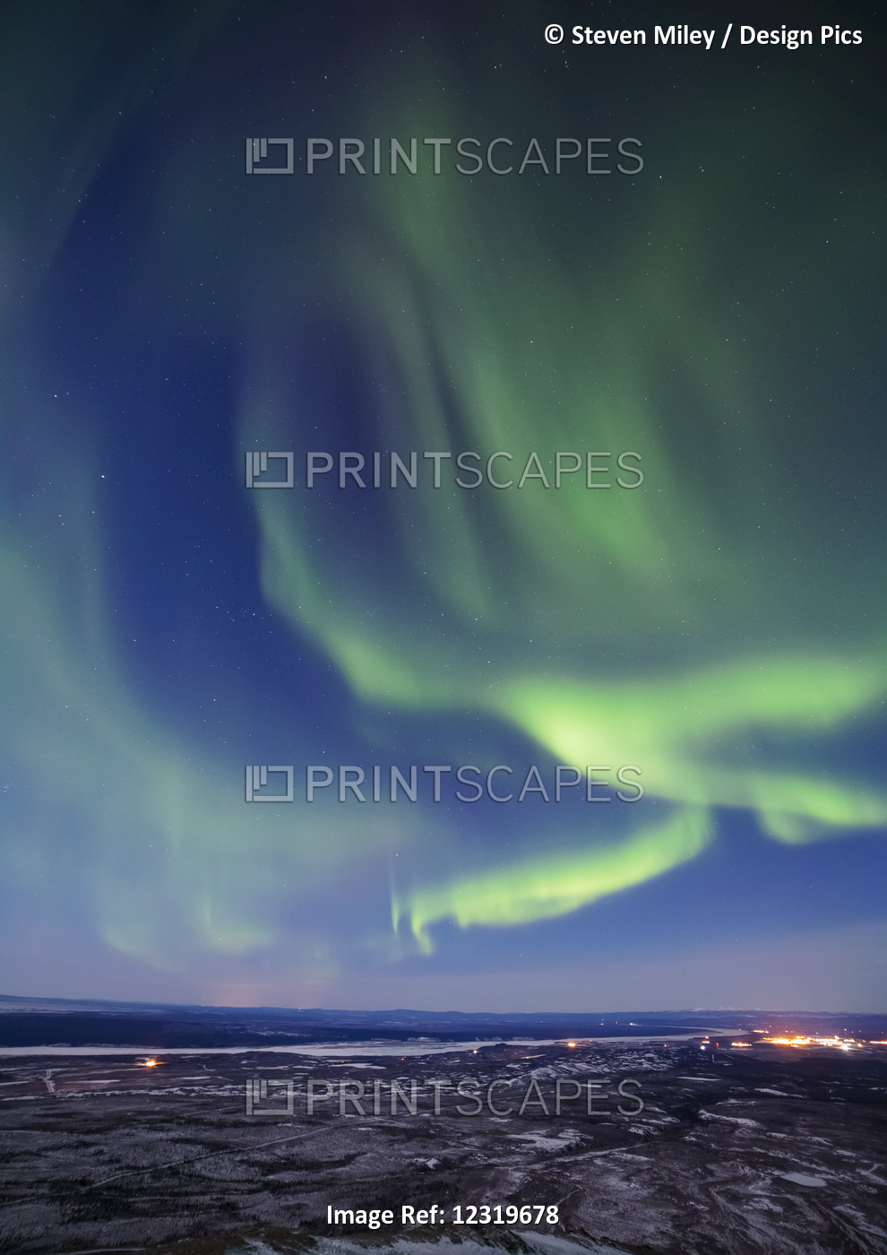 The Aurora Borealis Glows Over The Delta River And The Distant Lights Of Fort ...