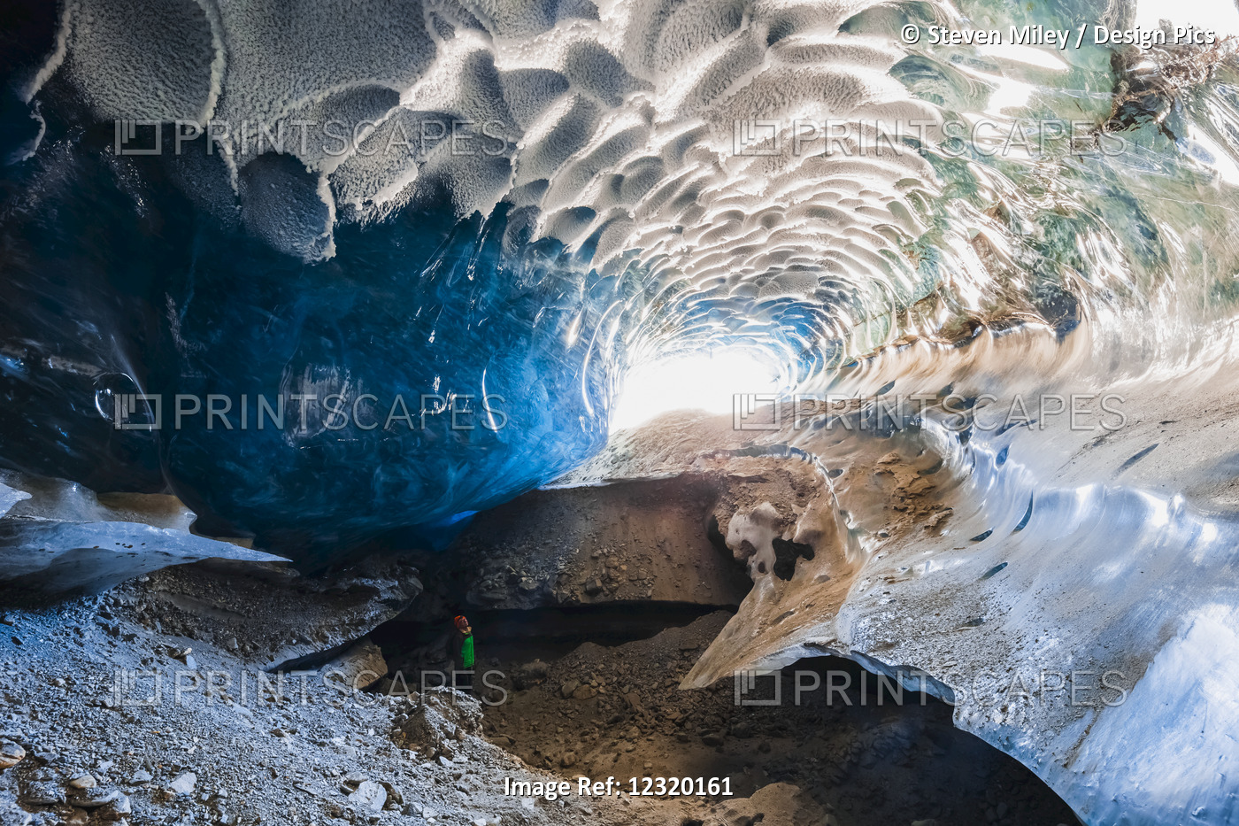 A Man Stands Inside A Cavernous Ice Cave Within Canwell Glacier In The Alaska ...