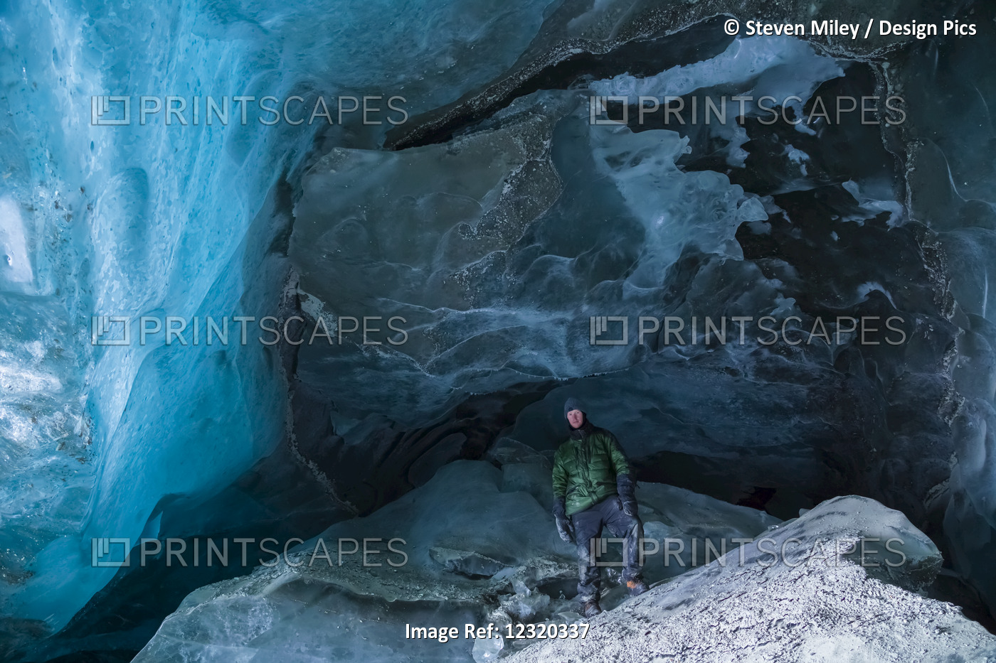 A Man Stands On A Large Piece Of Ice Inside A Canwell Glacier Cave In The ...