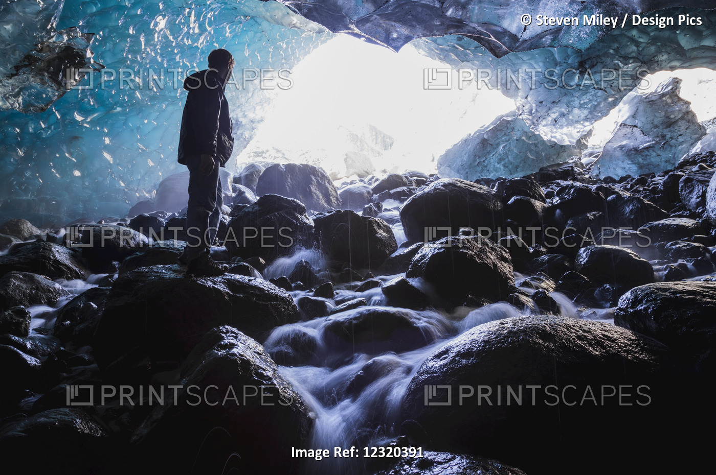 A Man Stands On A Boulder Inside An Ice Cave Beneath Root Glacier In ...