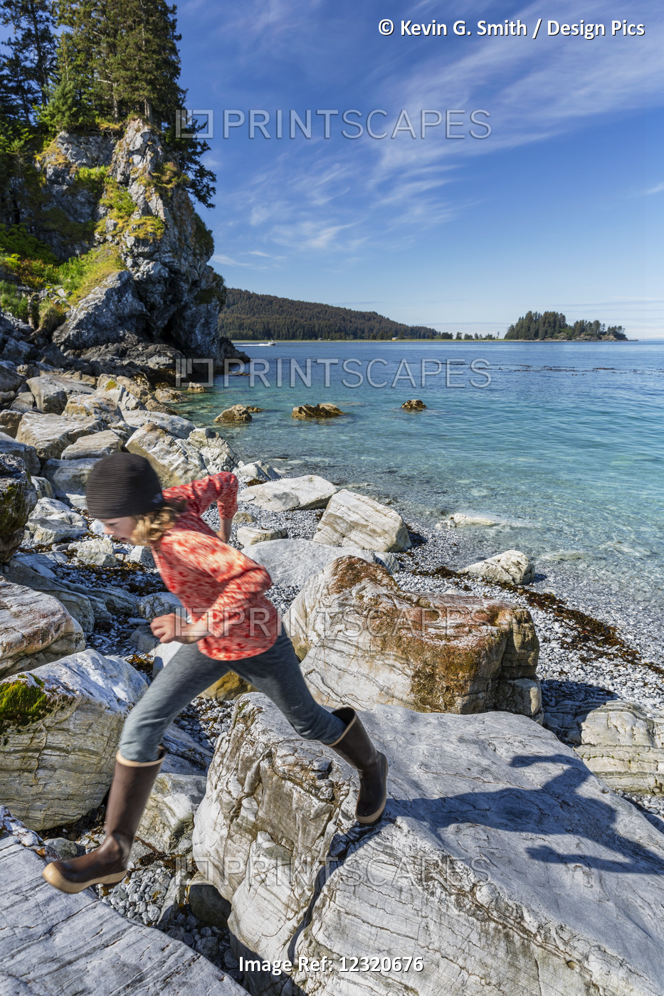 Young Girl Plays On Rocks Along The Shore Near Seldovia, Southcentral Alaska, ...