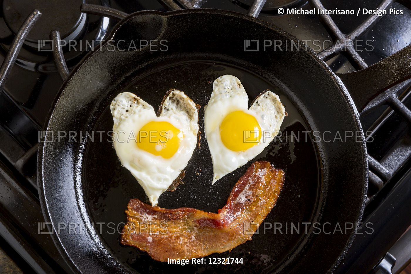 Close Up Of Heart Shaped Sunny Side Up Eggs And A Piece Of Bacon In A Cast Iron ...