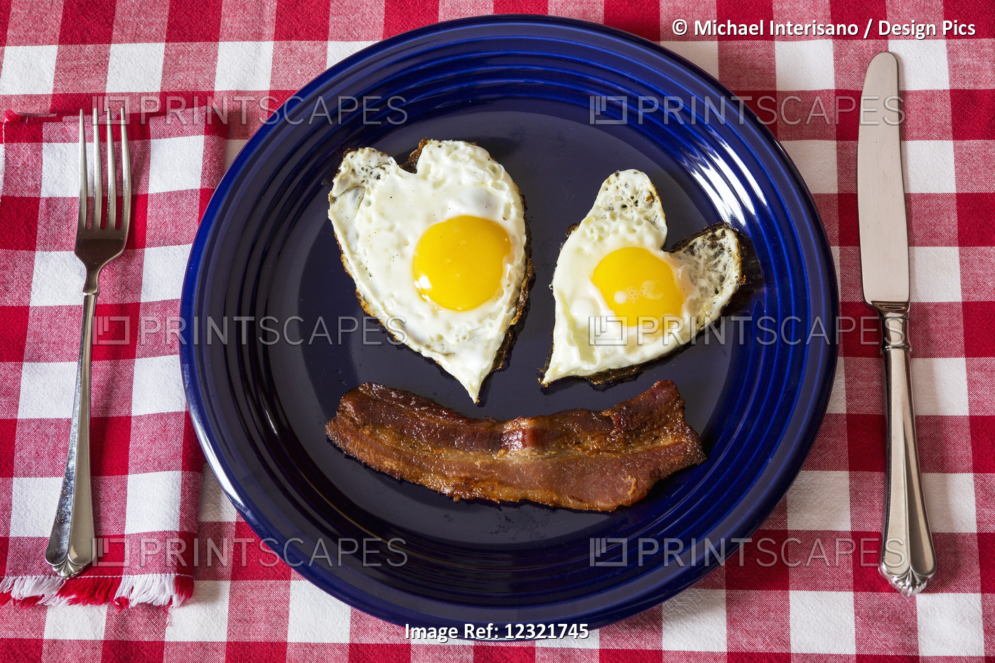Close Up Of Two Heart Shaped Sunny Side Up Eggs And A Crispy Strip Of Bacon On ...