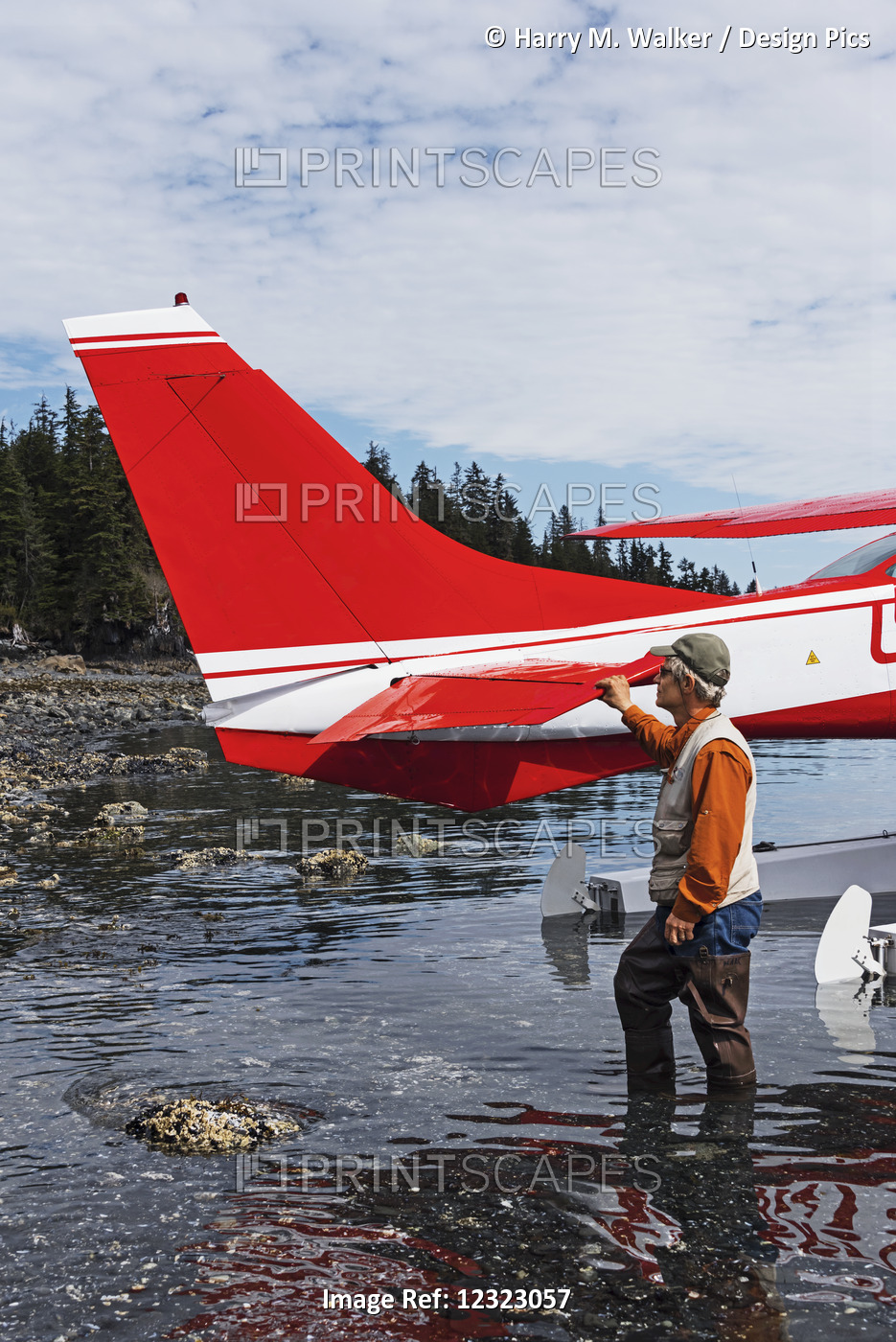 Man Standing Next To A Cessna 206 Float Plane In Hobo Bay, Port Wells, Prince ...