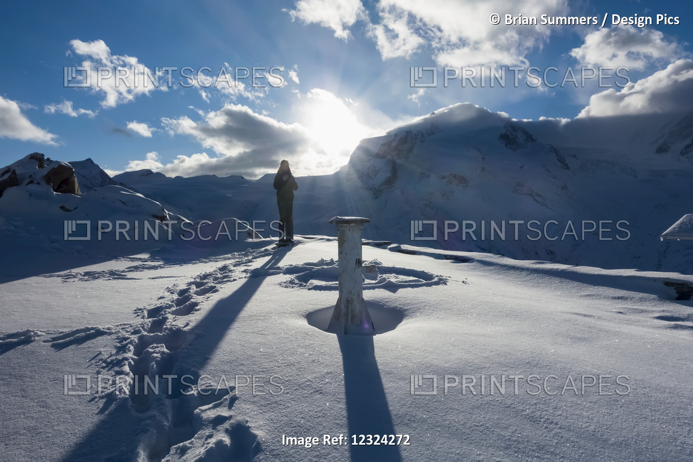 A Woman Stands In The Snow At Sunrise On  Gornergrat Summit, Monte Rosa, ...