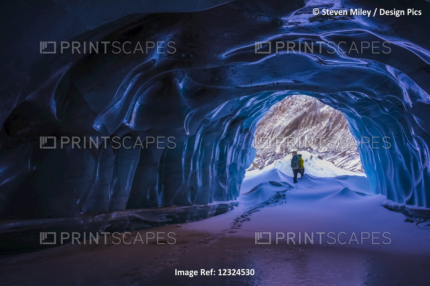 A Hiker Exits A Small Ice Cave While Exploring The Terminal Moraine Of Black ...