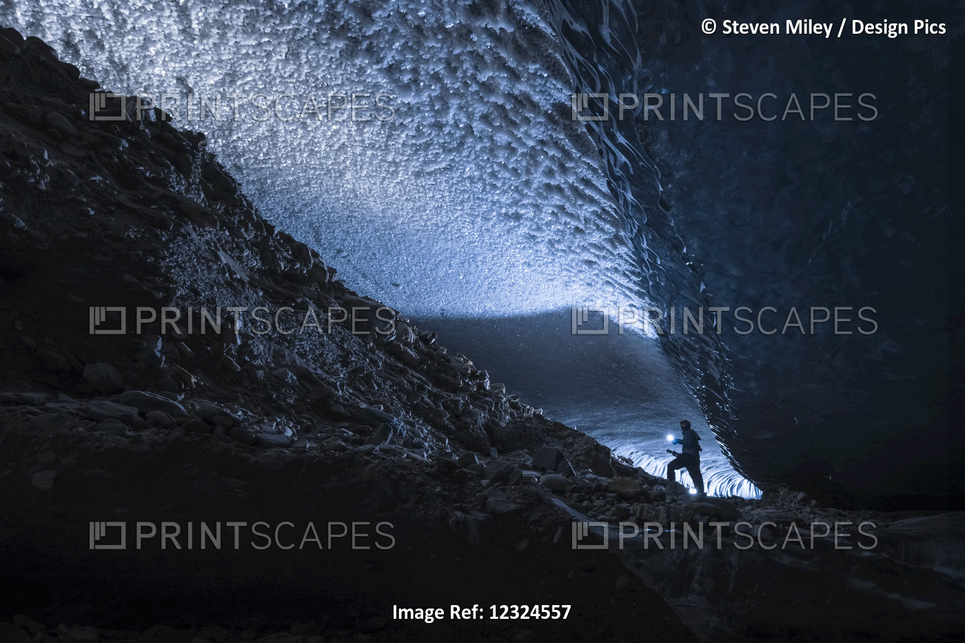A Man Illuminates A Dark Tunnel Beneath The Ice Of Canwell Glacier With A ...