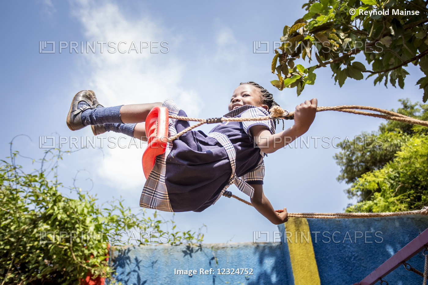 A Young Girl Swinging On A Swing In Mid-Air; Kampala, Uganda