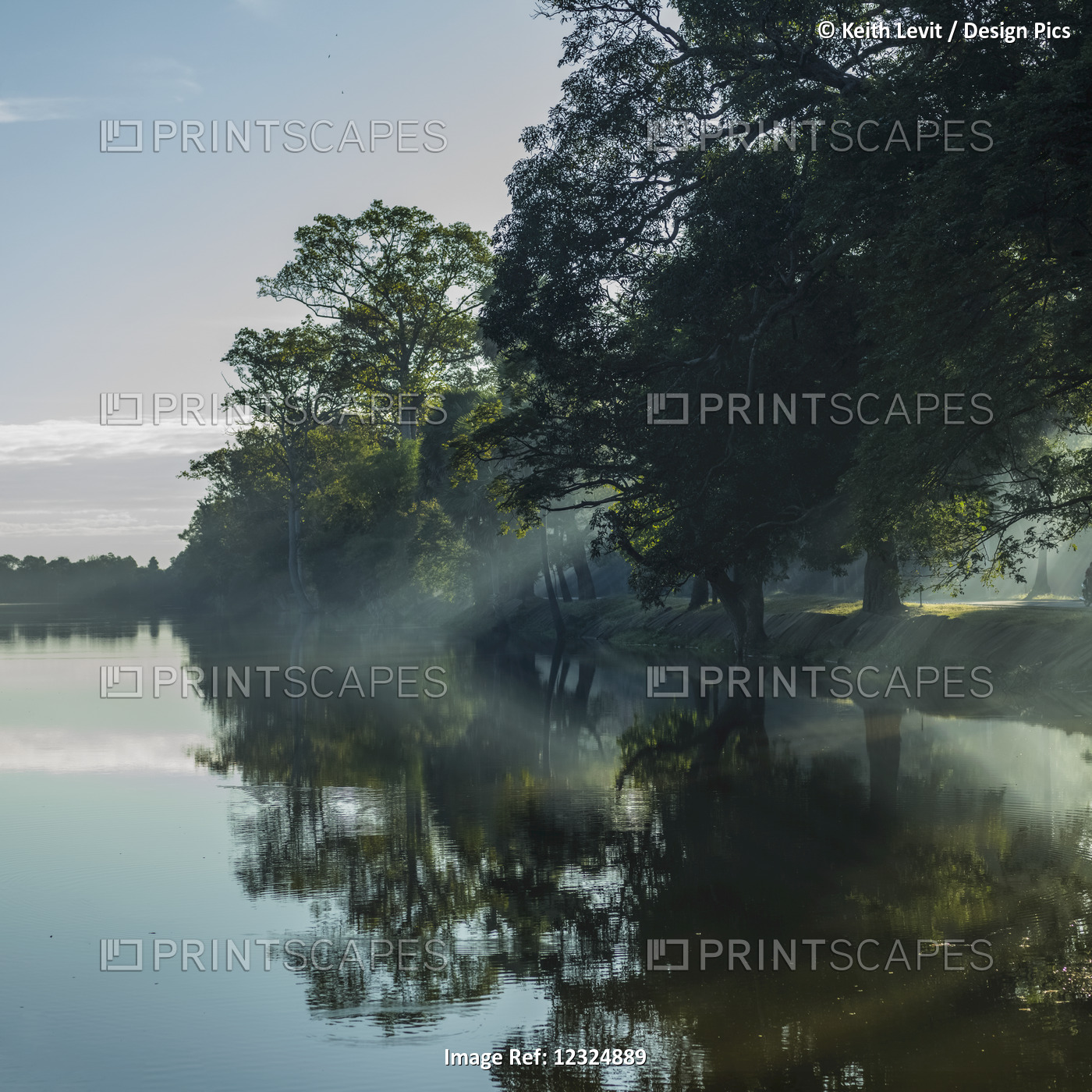 Tranquil Water Reflects Trees Along The Shoreline Through The Mist; Krong Siem ...