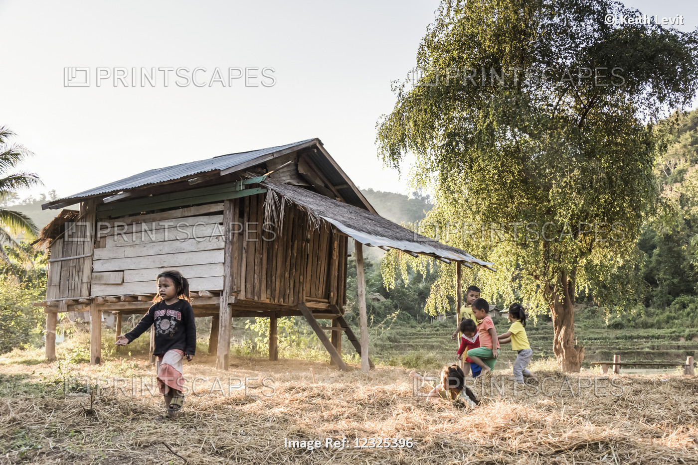 Young Children Play Together Beside A Wooden House On Stilts; Luang Prabang ...