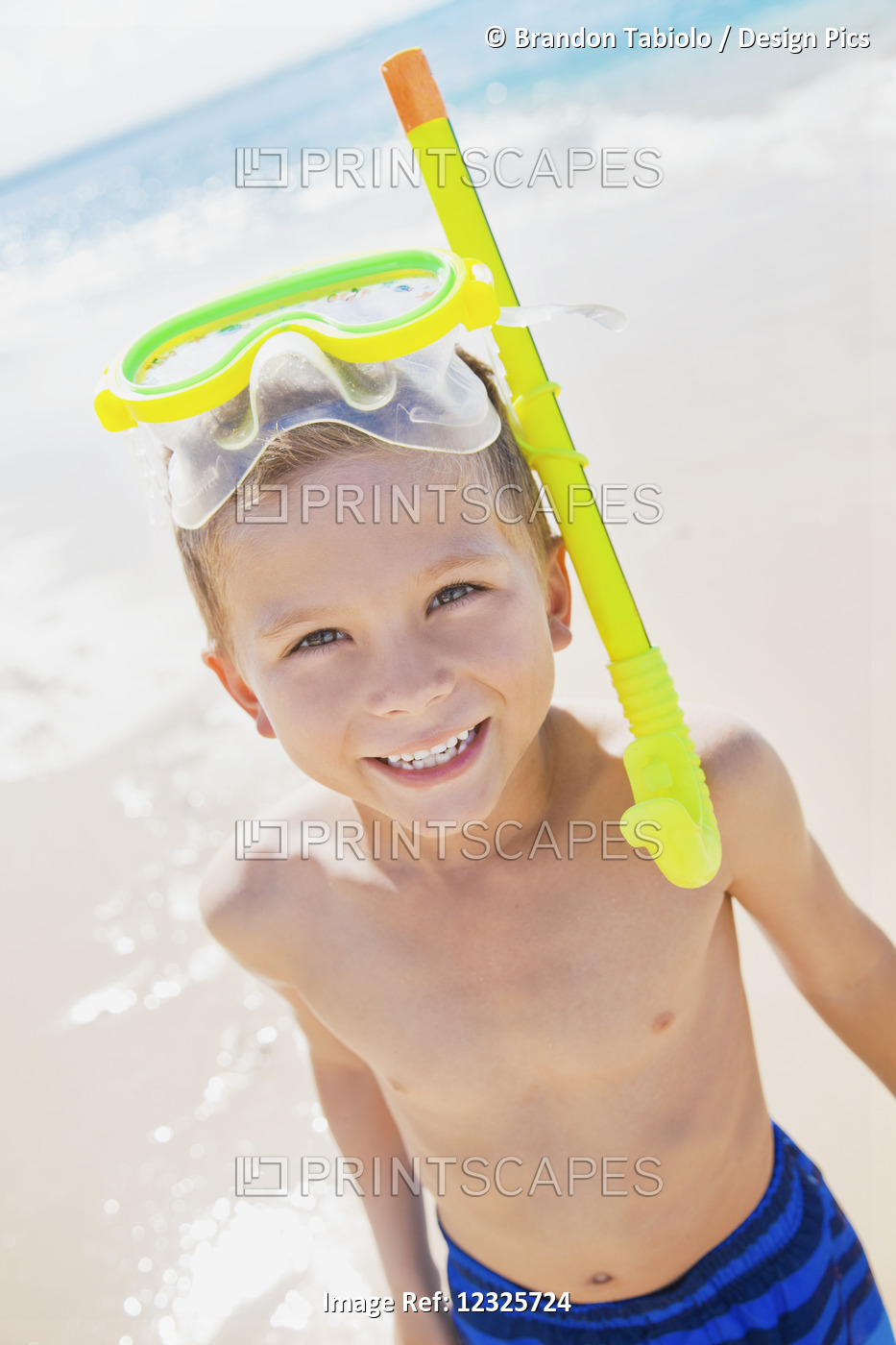 A Young Boy Smiling With Snorkel Gear At The Beach; Honolulu, Oahu, Hawaii, ...