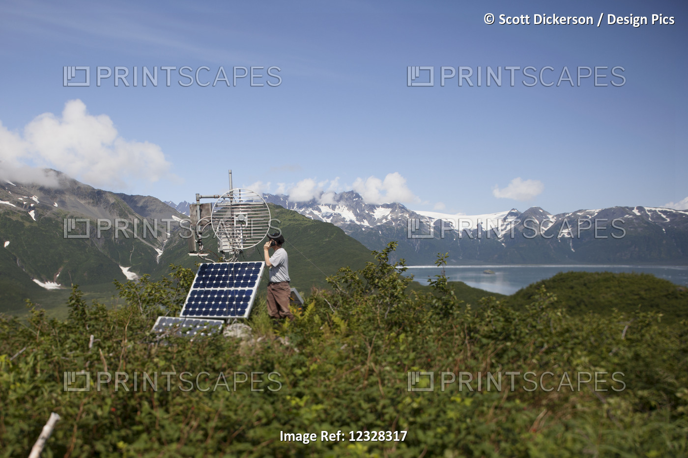 Person With Cell Phone Next To A Solar Panel With The Kenai Mountains In The ...