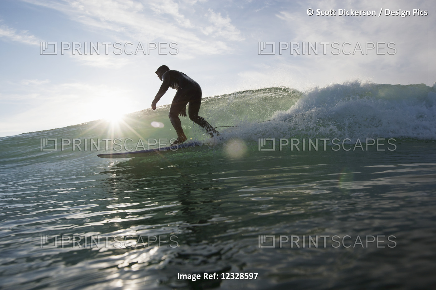 Man surfing and backlit by the sunlight, South-central Alaska; Homer, Alaska, ...