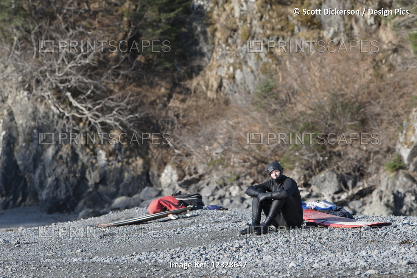 Surfer hanging out on the beach with his surfboard, Kenai Peninsula Outer ...