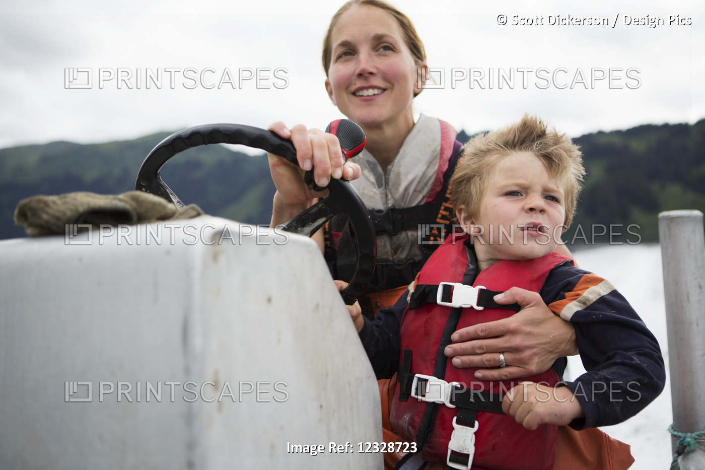 Female set-netter driving her skiff while holding her young son, South-central ...