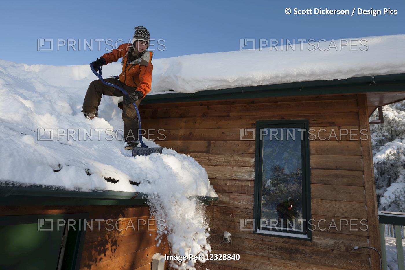 A Young Woman Removes Snow From The Roof Of Her House; Homer, Alaska, United ...