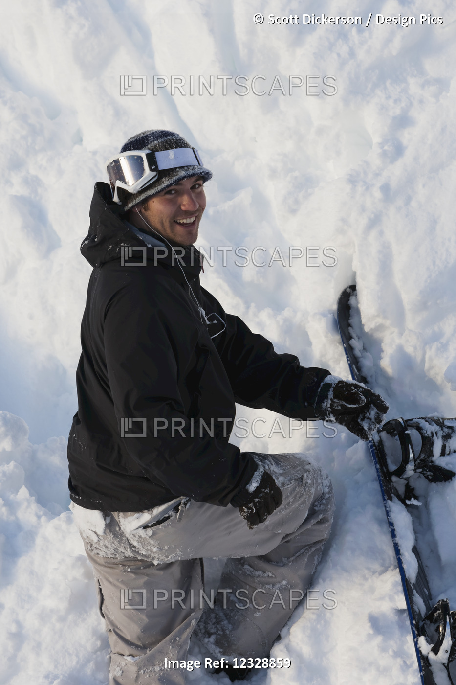 A Snowboarder Poses While Climbing Steep Terrain In Deep Snow With His ...