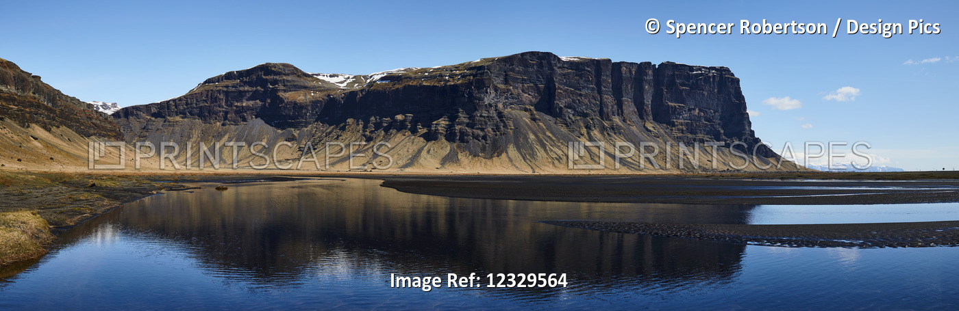 Rugged Cliffs Reflected In The Tranquil Water; Iceland