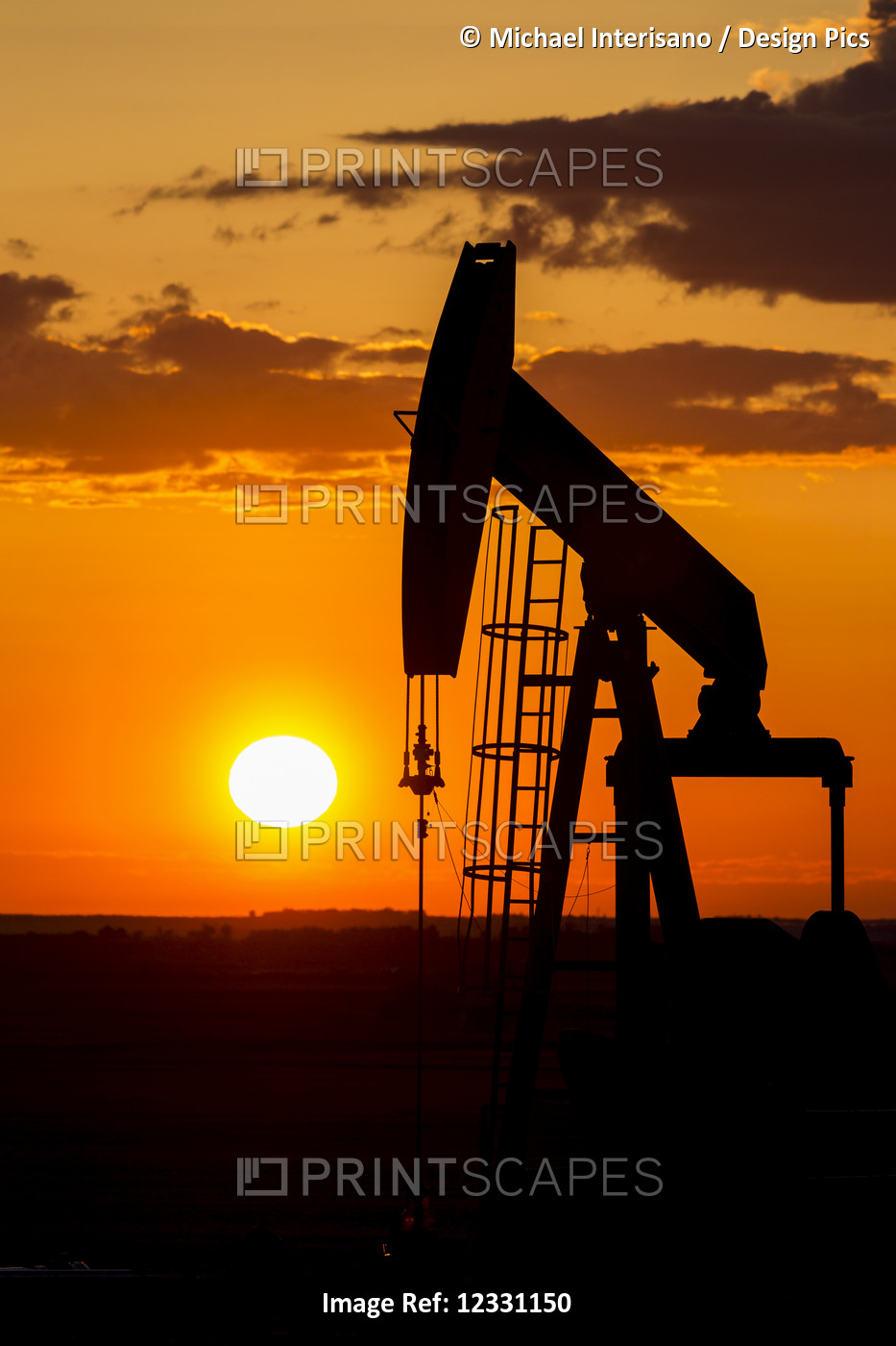 Silhouette Of A Pump Jack At Sunrise With A Colourful Orange Sun, Clouds And ...