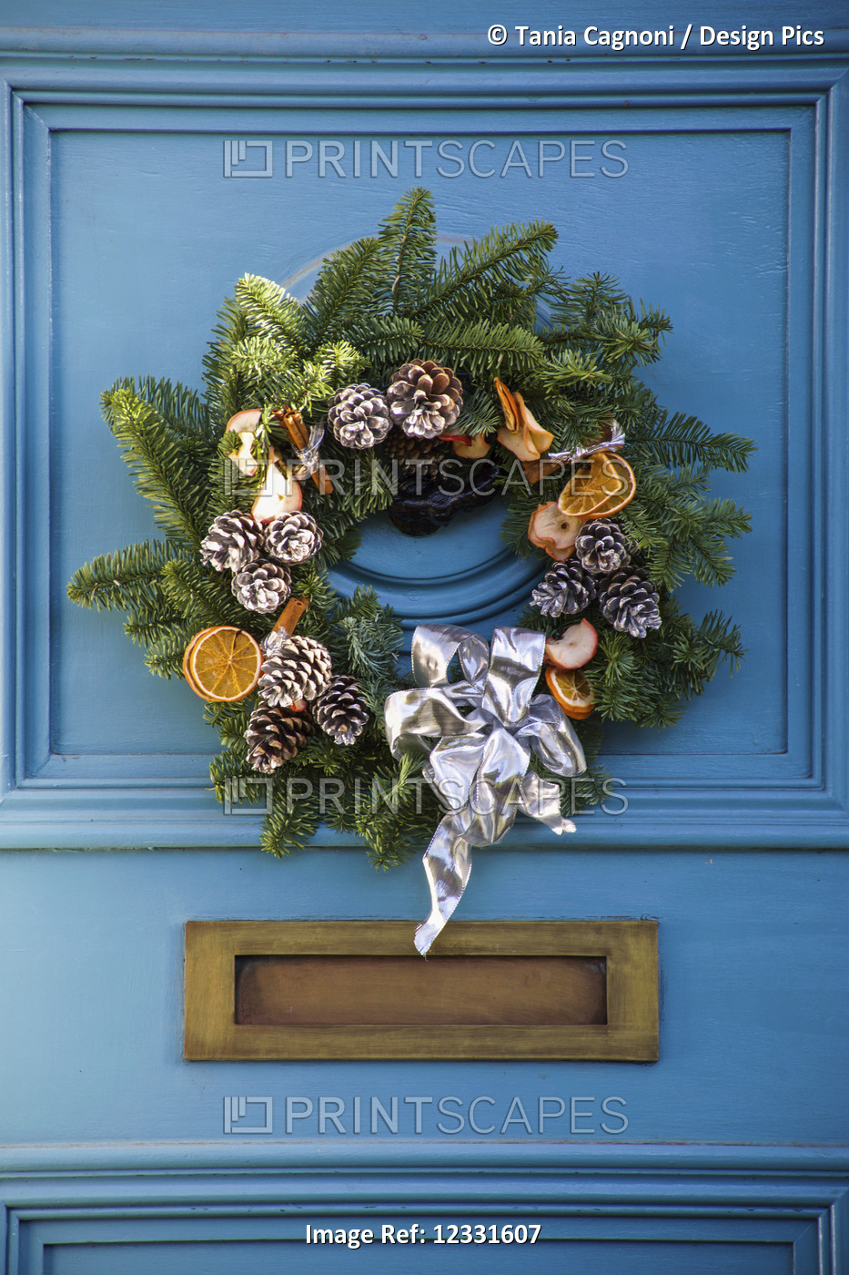 A decorative Christmas wreath on a blue house door; London, England