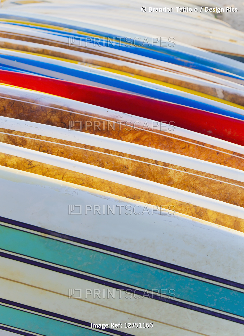 A stack of colourful longboard surfboards placed on the beach,; Waikiki, Oahu, ...