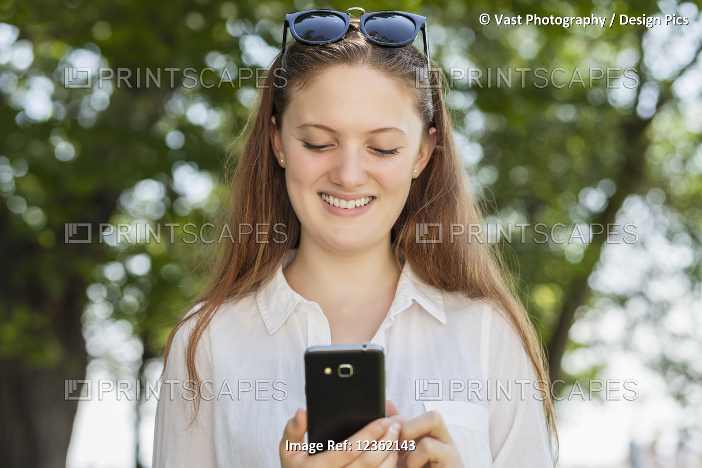Teenage girl using her smart phone, Woodbine Beach; Toronto, Ontario, Canada