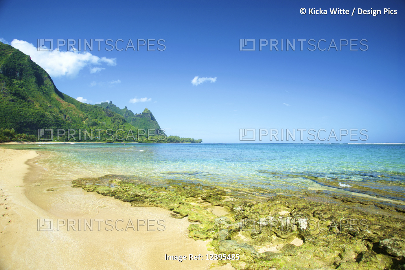 Clear turquoise ocean water and the rugged mountainous landscape on the island ...